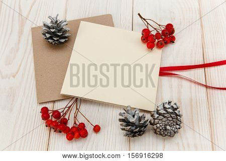 Christmas mokup.Empty cards with rowanberry and cones .White wooden table.Top view