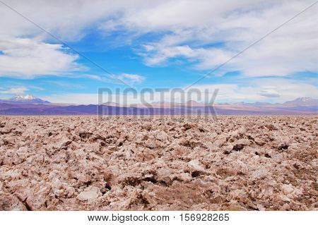 Panoramic view of salt flats in the Atacama desert with a mountain range in the background and a blue sky with clouds close to San Pedro de Atacama in Chile South America