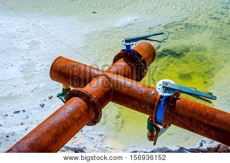 Rusted metal pipes at Chaqia Salt lakes Qinghai China