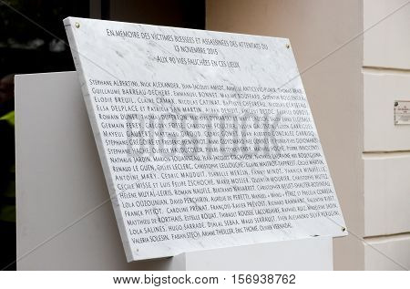 Paris, France - November 13, 2016: Commemorative stone with 90 names of victims in front the Bataclan