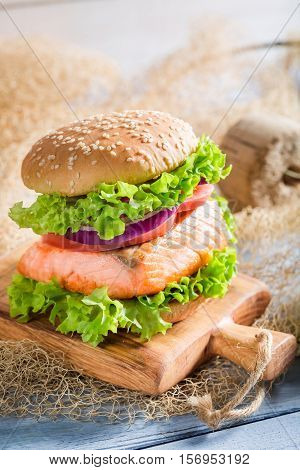 Delicious Fishburger With Salmon On Old Wooden Table