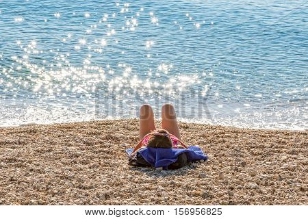 Sunbathing by the sea on the Tucepi town beach.