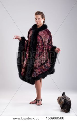 Young beautiful brunette in an embroidered handmade tippet on an isolated background