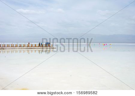 CHAKAZHEN CHINA - JUNE 23: People taking photos of the Chaqia salt lake and its reflection. Chaka or Chakayan lake is one of the most famous inland salt lakes. June 2016