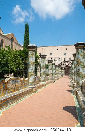 NAPLES, ITALY - AUGUST 1, 2018: Sunny cloister of the Clarisses decorated with majolica tiles from Santa Chiara Monastery in Naples, Italy. 