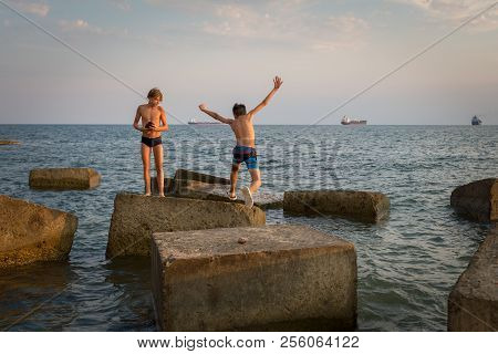 Gizelle-dere Village, Russia, August 07, 2018: Boy Jumps From One Concrete Block To Another On The B