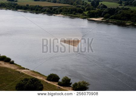 A Large River In Central Europe With A Sandy Island. A Sandstorm In The Middle Of A Large River.