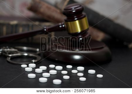 Judge's Gavel With Handcuffs, Drugs On Wooden Table