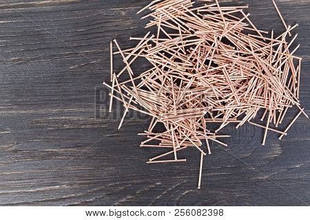 Copper Finish Nails Lying In A Pile, Close-up Of Metal Materials Used In Construction, Top View On A