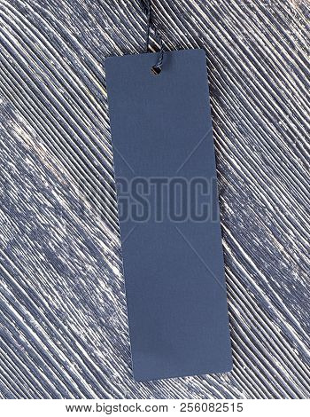 One Black Label For Clothes Or Other Things On The Background Of A Black Wooden Old Board Painted Wi