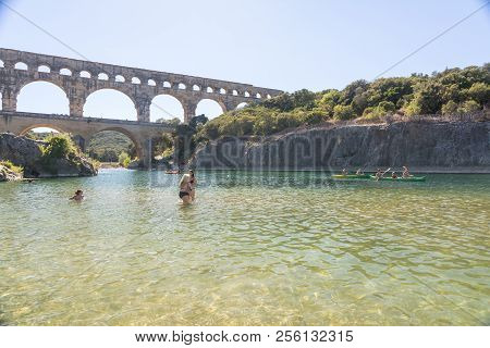 Remoulins,france-august 12, 2016:people Swim And Canoe Near The Pont Du Gard Roman Aqueduct During A