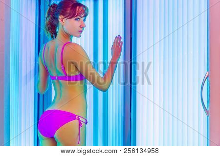 Slim Woman Standing In Solarium Getting Sun Tan