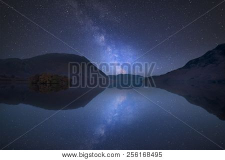 Stunning Vibrant Milky Way Composite Image Over Landscape Of Crummock Water In Lake District England