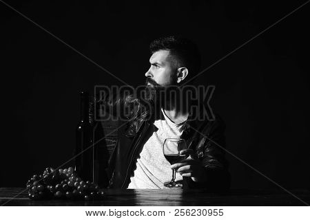 Sommelier Tastes Expensive Drink. Man With Beard Holds Glass Of Wine On Dark Brown Background. Winet