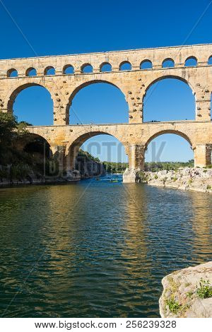 Remoulins,france-august 12, 2016:people Swim And Canoe Near The Pont Du Gard Roman Aqueduct During A