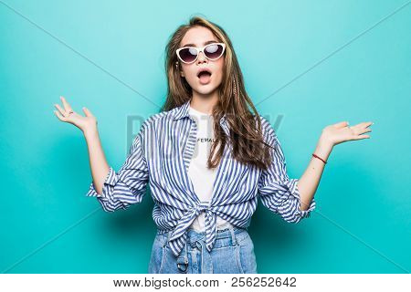 Pretty Smiling Woman In Blue Shirt Isolated On Blue Background Asking You To Make A Choice Between T