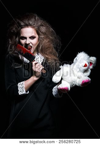 Horror Shot: A Scary Demonic Girl With Torn Rabbit Toy And Bloody Knife In Hands