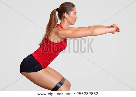 Sporty Beautiful Strong Female Does Physical Exercises With Fitness Gum, Has Whippy Body, Stands Sid