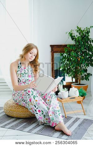 Pretty Young Woman Rading A Book In Boho Interior.
