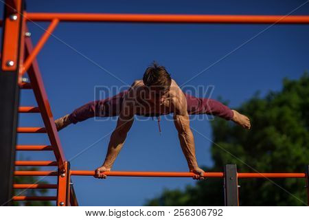 Muscular Man Making Planche On The Street. Street Workout