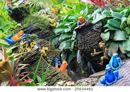 Coloridas ranas y fuente de cerámica mini en el jardín tropical, Tailandia