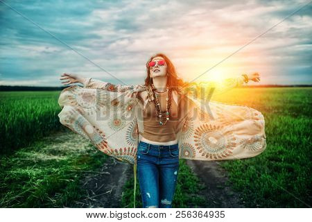 Fashion female model walking on a country road. Contemporary bohemian style. Spirit of freedom. Fashion shot. Bohemian, bo-ho style.