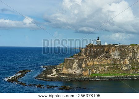 Scenic View Of Historic Colorful Puerto Rico City In Distance With Fort In Foreground From The Sea
