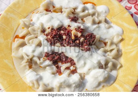 Close-up Traditional Taste Turkish Ravioli With Yellow Banded Plate With Tomato Sauce And Yogurt