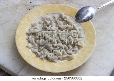 Perspective Top Shoot Of Turkish Ravioli With Yellow Banded Plate
