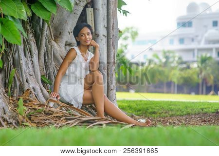 A Beautiful African-looking Girl With Black Short Hair And White Dress Pousing Near The Big Beautifu