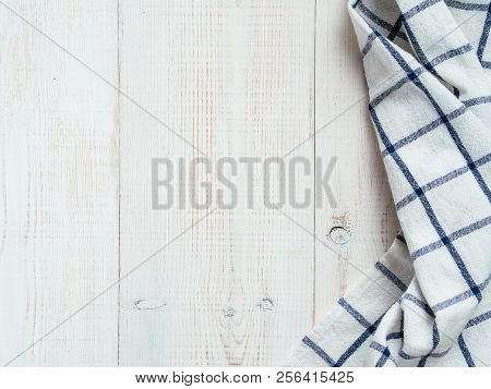 View From Above On White Wooden Table With Linen Kitchen Towel Or Textile Napkin. Blue Tablecloth On