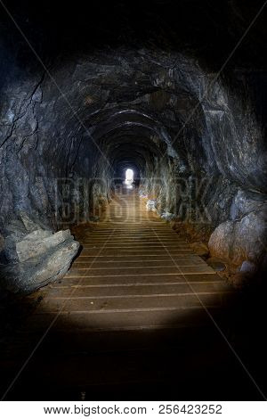 Light From A Flashlight Shining Through A Narrow Cave In The Tow