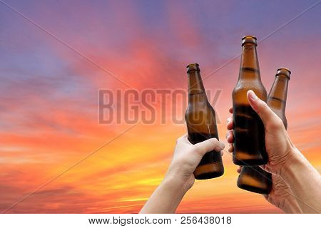 Hands Holding Three Beer Bottles And Happy Enjoying Harvest Time Together To Clinking Glasses At Out