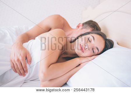 Nice And Beautiful Girl Sleeps In Fresh And White Bed. She Keeps Hands Under Head. Guy Is Lying Behi