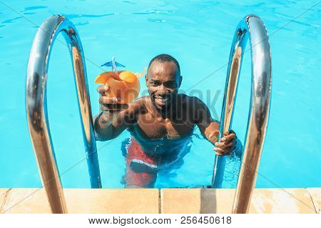 The Portrait Of Happy Smiling Beautiful Man At The Swimming Pool. Female Caucasian Model At Blue Wat