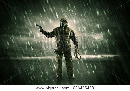 Terrorist in a stormy space with gas mask on his hand and weapons on his arm
