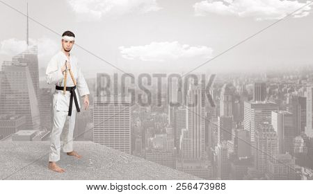 Young karate trainer doing karate tricks on the top of a metropolitan city