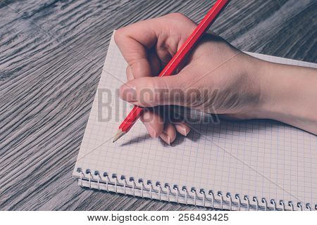Felame Hand Writing With A Pencile On Notebook On Gray Wooden Background. Vintage Effect
