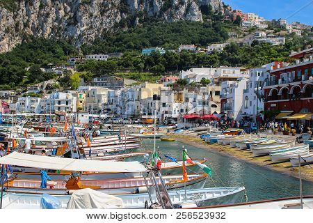 Busy Beach With Boats Docked And People Walking In The Island Of Capri , Italy