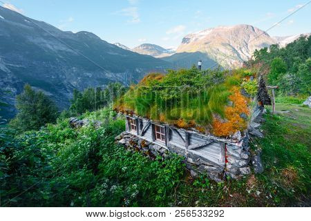 Typical norwegian old wooden houses with grass roofs near Sunnylvsfjorden fjord and famous Seven Sisters waterfalls, western Norway.
