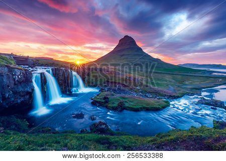 Colorful sunrise on Kirkjufellsfoss waterfall. Amazing morning scene near Kirkjufell volkano, Iceland, Europe.
