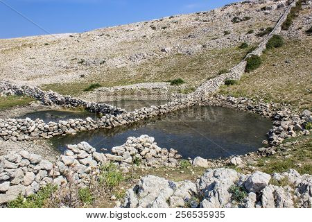 Diviska Pond With Stone Wall In Water, Island Krk Croatia