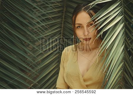 Stunning Woman Posing On Palm Leaves Background