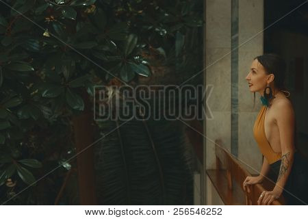 Pretty Young Woman Standing In Hotel Balcony, Looking Out Enjoyi