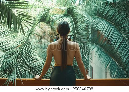 Exotic Beautiful Woman Resting On The Balcony While On Her Vacat