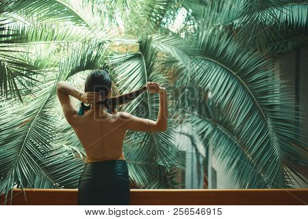 Exotic Beautiful Woman Resting On The Balcony While On Her Vacat