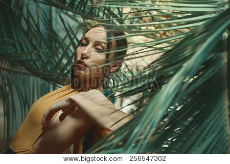 Fashionable Exotic Woman Posing Among Tropical Plants