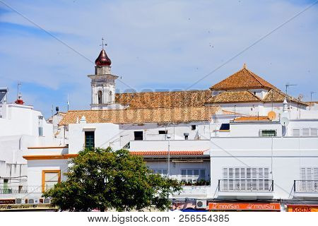 Ayamonte, Spain - June 11, 2017 - Town Buildings With The Mercy Church Tower To The Rear, Iglesia De