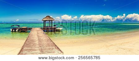 Sandy tropical Wolmar beach at sunny day. Jetty on the foreground. Beautiful landscape panorama. Mauritius