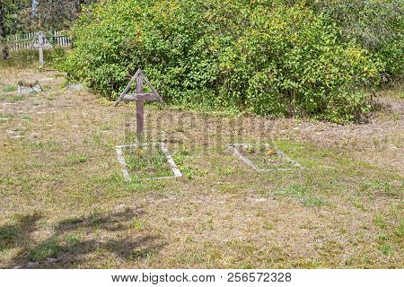 Old Abandoned Cemetery In Sunny Summer. Wooden Weathered Cross.
